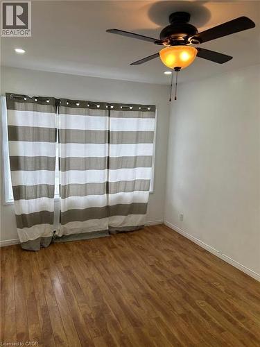Bright interior space featuring wood-finish flooring, a window with horizontal striped drapes, a ceiling fan with integrated lighting, and recessed ceiling lights - 744 Parkview Crescent, Cambridge, ON - Indoor Photo Showing Other Room