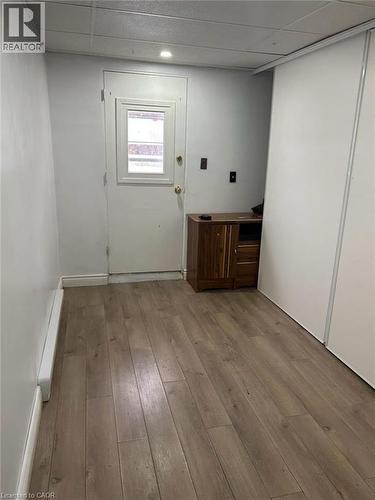 Interior space featuring wood-finish flooring, white walls, and a white door with a window pane - 744 Parkview Crescent, Cambridge, ON - Indoor Photo Showing Other Room