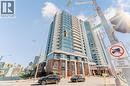 Modern high-rise building featuring extensive glass curtain walls, individual balconies, brick facade elements, and a prominent street-level presence - 5 Wellington Street S Unit# 904, Kitchener, ON  - Outdoor With Facade 