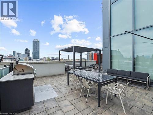 Spacious rooftop patio featuring paver flooring, a built-in outdoor kitchen with a grill, and a modern pergola structure - 5 Wellington Street S Unit# 904, Kitchener, ON - Outdoor With Deck Patio Veranda