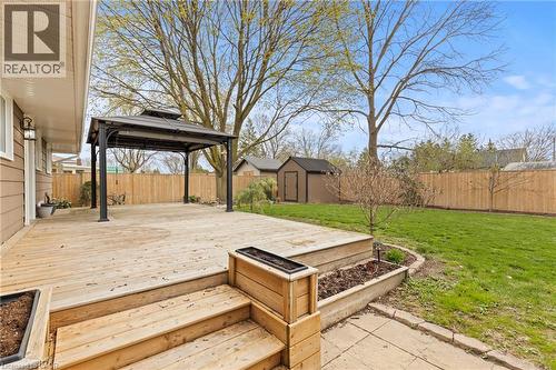 Expansive wooden deck featuring a gazebo, built-in planters, and steps to a stone paver path - 45 Driftwood Drive, Brantford, ON - Outdoor With Deck Patio Veranda
