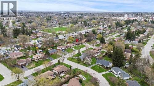 Aerial perspective showcasing residential neighborhood streets, surrounding green spaces, and a distant water tower - 45 Driftwood Drive, Brantford, ON - Outdoor With View