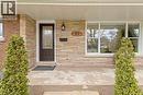Front facade featuring a dark paneled entry door with decorative glass, stacked stone veneer, and a brick accent wall - 45 Driftwood Drive, Brantford, ON  - Outdoor With Deck Patio Veranda With Exterior 