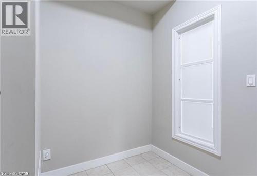 This area features light gray walls, white trim, and a tiled floor - 833 King Street E, Hamilton, ON 