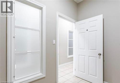 The property features a white paneled door with a silver-tone doorknob, and windows with white frames - 833 King Street E, Hamilton, ON 