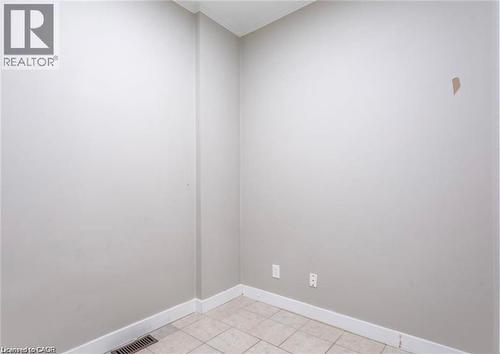 This room features light-colored walls, white baseboards, and tiled flooring - 833 King Street E, Hamilton, ON 