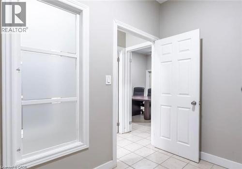The interior features light-colored walls, white trim, and a window with frosted panes - 833 King Street E, Hamilton, ON 