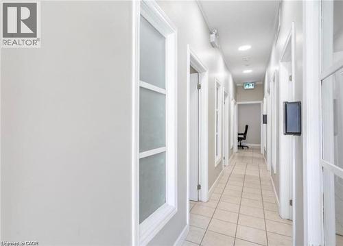 The property features a hallway with light-colored tile flooring and white walls - 833 King Street E, Hamilton, ON 