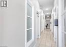 The property features a hallway with light-colored tile flooring and white walls - 833 King Street E, Hamilton, ON 