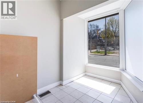 This room features large windows and tiled flooring, providing ample natural light - 833 King Street E, Hamilton, ON 