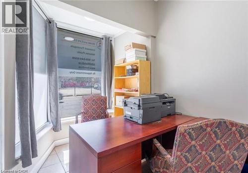 This well-lit office space features a large window, providing natural light, and tiled flooring - 833 King Street E, Hamilton, ON 