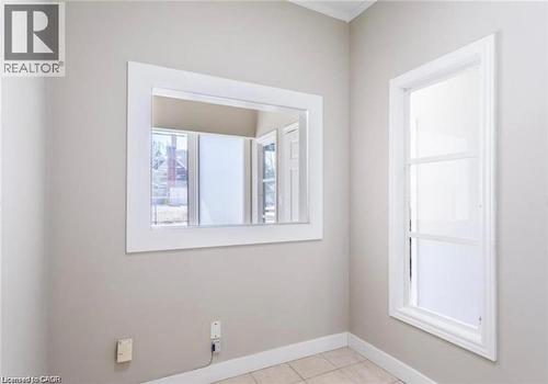 This room features light-colored walls, white trim, and tiled flooring - 833 King Street E, Hamilton, ON 