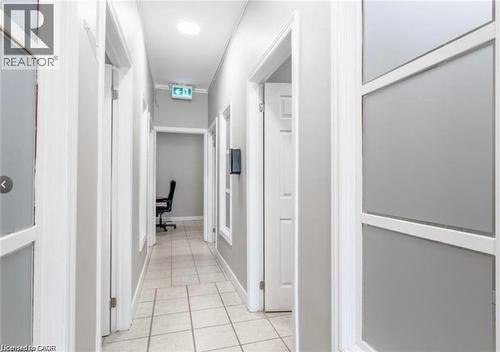 The property features a well-lit hallway with tiled flooring and recessed lighting - 833 King Street E, Hamilton, ON 