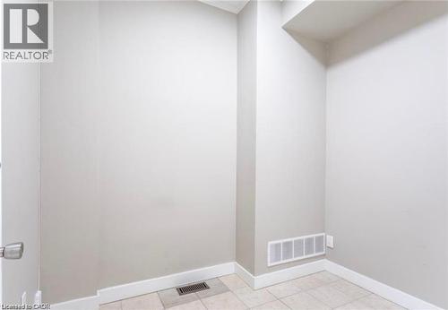 This area features light-colored walls, white baseboards, and tiled flooring - 833 King Street E, Hamilton, ON 