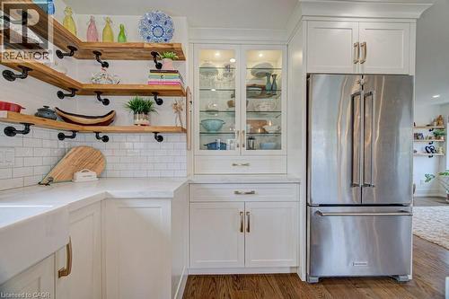 Kitchen featuring wood-finish open shelving, white subway tile backsplash, and a farmhouse-style sink - 1486 Augustine Drive, Burlington, ON - Indoor Photo Showing Kitchen
