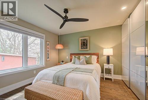 Spacious bedroom featuring wood-finish flooring, a large window, a ceiling fan, recessed lighting, and built-in mirrored wardrobe doors - 1486 Augustine Drive, Burlington, ON - Indoor Photo Showing Bedroom