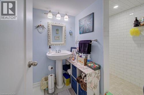 Pedestal sink featuring a chrome faucet and an ornate framed mirror - 1486 Augustine Drive, Burlington, ON - Indoor Photo Showing Bathroom