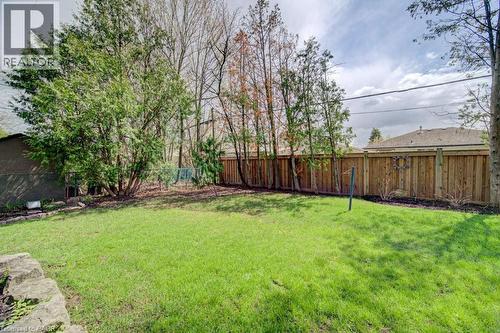 Expansive rear lawn framed by a tall wood privacy fence - 1486 Augustine Drive, Burlington, ON - Outdoor