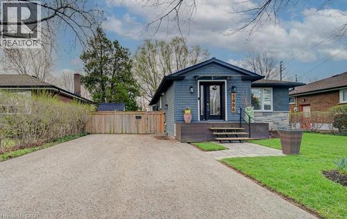 Blue shingle siding exterior with stone accents and a dark wood porch - 1486 Augustine Drive, Burlington, ON - Outdoor