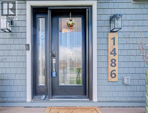 Entryway featuring a black door with decorative glass, a sidelight, and gray shake siding - 1486 Augustine Drive, Burlington, ON - Outdoor With Exterior