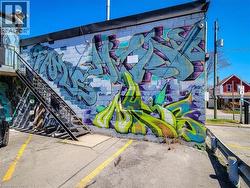 Exterior block wall featuring colorful graphic art and a black metal exterior staircase - 