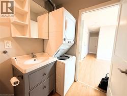 Dedicated laundry area featuring a stacked washer and dryer unit - 