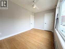 Room featuring light wood-finish flooring, light gray wall paint, and white trim - 
