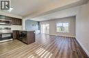 Open-concept living area featuring wood-finish flooring, a kitchen island with a sink and stainless steel appliances, recessed lighting, and sliding glass doors to the exterior - 80 Miranda Path, Elmira, ON  - Indoor Photo Showing Kitchen 