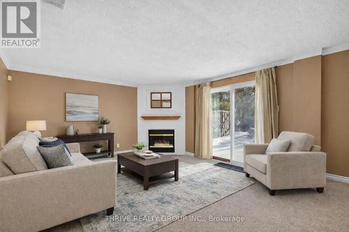This photo has been virtually staged - 3 - 80 Acorn Crescent, London North (North F), ON - Indoor Photo Showing Living Room With Fireplace