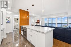 Kitchen island featuring a white countertop and integrated stainless steel appliances - 