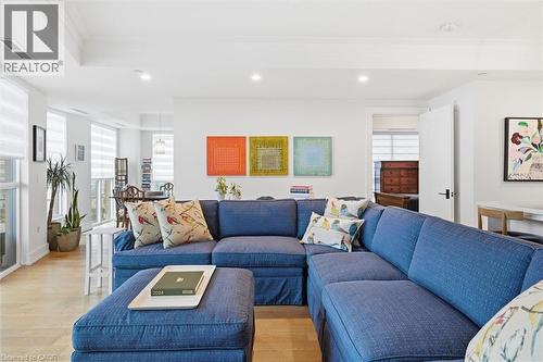 Open concept living area with recessed lighting, wood-finish flooring, white crown molding, and abundant natural light from multiple windows - 2060 Lakeshore Road Unit# 1501, Burlington, ON - Indoor Photo Showing Living Room