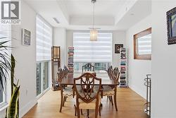 Bright dining area featuring hardwood flooring, recessed lighting, and a tray ceiling - 