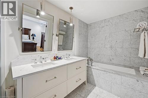 Bathroom featuring a double vanity with stone countertops, undermount sinks, and wall-mounted mirrors - 2060 Lakeshore Road Unit# 1501, Burlington, ON - Indoor Photo Showing Bathroom