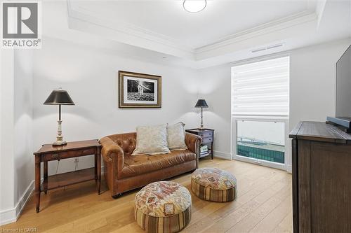 Tray ceiling with crown molding, wood-finish flooring, and a large window with privacy blinds - 2060 Lakeshore Road Unit# 1501, Burlington, ON - Indoor