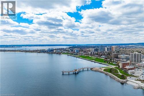 Expansive waterfront with a pier, surrounded by a city skyline and green spaces, under a partly cloudy sky - 2060 Lakeshore Road Unit# 1501, Burlington, ON - Outdoor With Body Of Water With View