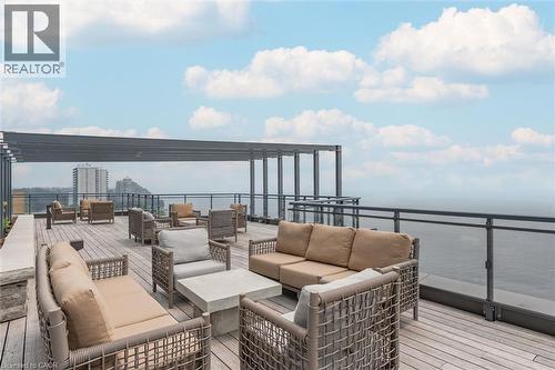 Rooftop deck featuring wood-finish flooring, a metal pergola structure, and glass panel railings - 2060 Lakeshore Road Unit# 1501, Burlington, ON - Outdoor With Body Of Water With Balcony With View