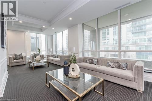 Spacious common area featuring floor-to-ceiling windows, patterned carpet flooring, recessed lighting, and a tray ceiling with crown molding - 2060 Lakeshore Road Unit# 1501, Burlington, ON - Indoor Photo Showing Living Room