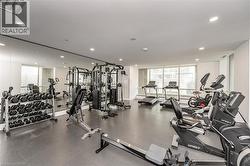 Fitness center featuring a mirrored wall, recessed lighting, and multiple exercise machines - 