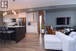 Open-concept living space with wood-finish flooring - 