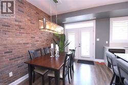 Exposed brick accent wall and wood-finish flooring define this space - 