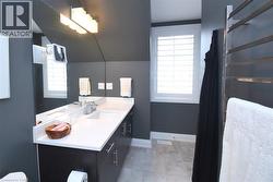 Vanity area featuring an integrated sink, white countertop, and dark wood-finish cabinetry with brushed nickel hardware - 