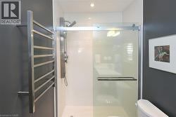 Shower enclosure featuring a sliding glass door and a rainfall shower head - 