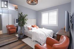 Room featuring wood-finish flooring, a contemporary ceiling light fixture, and a window with white louvered shutters - 