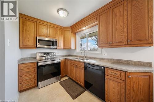 Kitchen with wood cabinetry, stainless steel appliances, and a double basin sink - 2223 Hall Road, Binbrook, ON - Indoor Photo Showing Kitchen With Double Sink