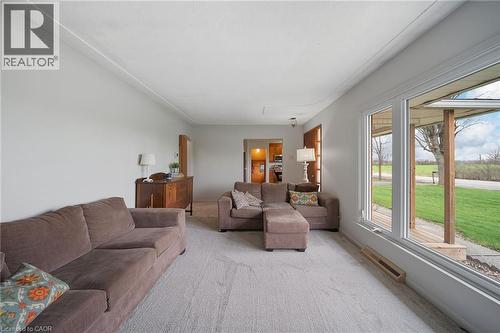 Light-filled room featuring a large picture window, light gray carpeting, and white painted walls - 2223 Hall Road, Binbrook, ON - Indoor Photo Showing Living Room