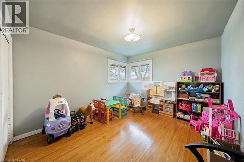 Light-filled room featuring wood-finish flooring, two large windows with white trim, and a ceiling-mounted light fixture - 2223 Hall Road, Binbrook, ON - Indoor
