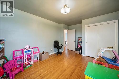 Bright room featuring wood-finish flooring, light-toned walls, and a ceiling-mounted light fixture - 2223 Hall Road, Binbrook, ON - Indoor