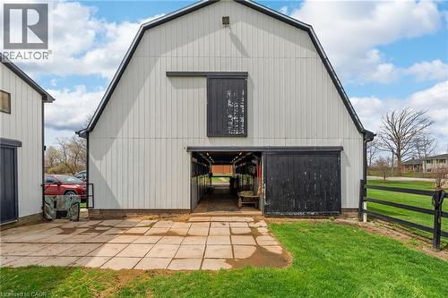 Gambrel-roof barn with white vertical siding and black trim - 2223 Hall Road, Binbrook, ON - Outdoor With Exterior