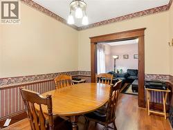 Dining area featuring wood-finish flooring and a decorative chandelier - 