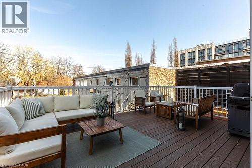 Spacious outdoor deck featuring composite decking, white railing, privacy screen, and exterior lighting - 128 Canada Street, Hamilton, ON - Outdoor With Deck Patio Veranda With Exterior